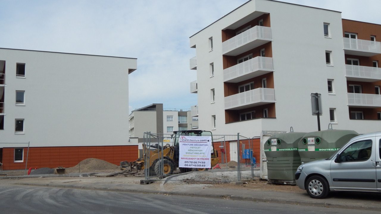 La bâche Shahin Peinture 2000 sur la clôture d'un chantier de logements